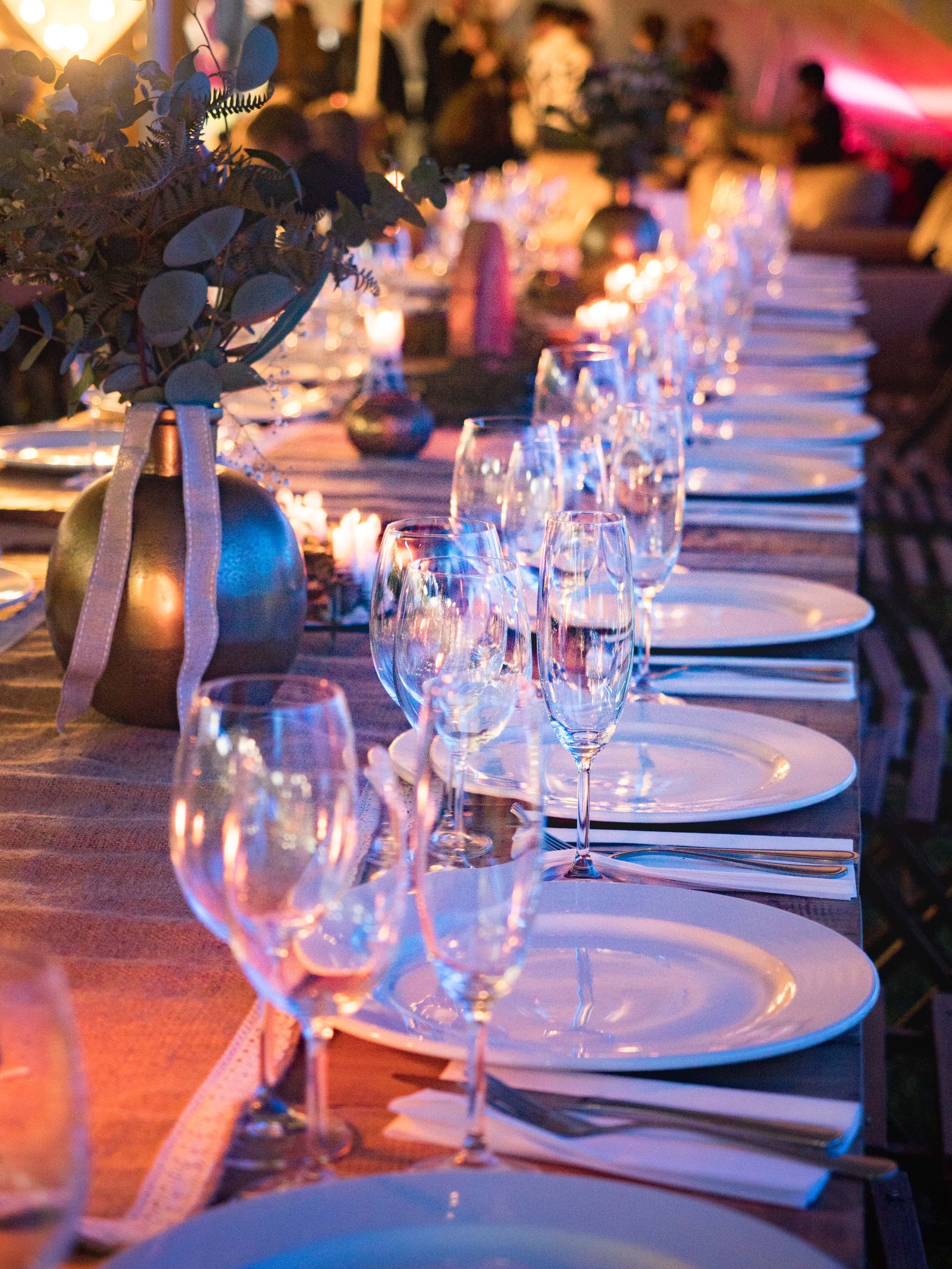 Mesa de banquete decorada com taças e velas